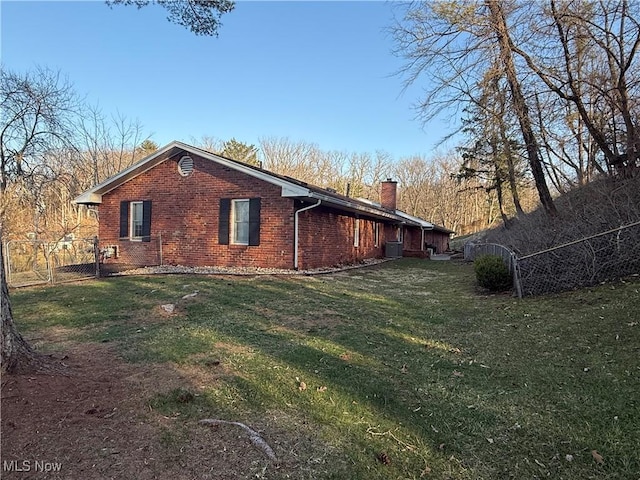 106 Wildwood Dr, Marietta, OH 45750 - view of home's exterior with fence, a yard, a chimney, central air condition unit, and brick siding