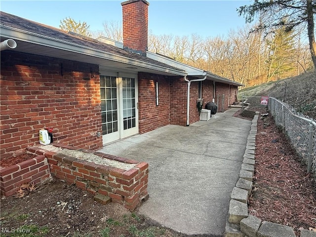 106 Wildwood Dr, Marietta, OH 45750 - rear view of house with a patio area, a chimney, brick siding, and fence