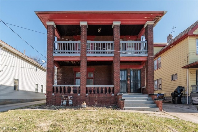 view of front of property featuring brick siding and a balcony