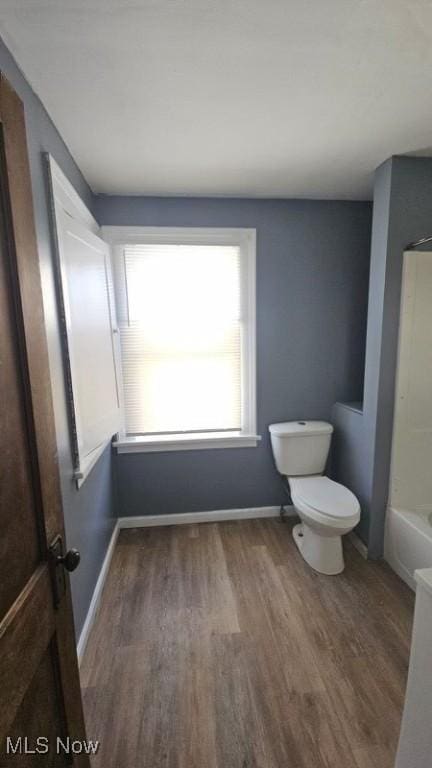 bathroom featuring baseboards, toilet, and wood finished floors