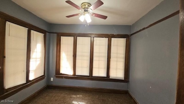 spare room featuring baseboards, ceiling fan, and carpet floors
