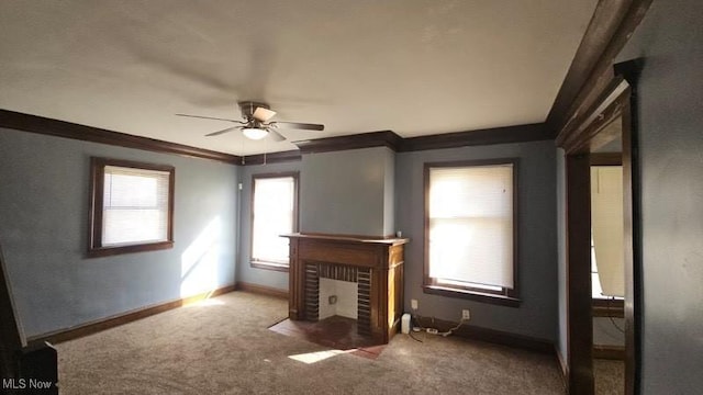 unfurnished living room with crown molding, carpet, baseboards, and ceiling fan