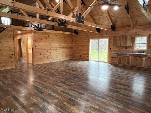 2239 Eureka Rd, Ashtabula, OH 44004 - unfurnished living room with a ceiling fan, wooden walls, high vaulted ceiling, and beamed ceiling