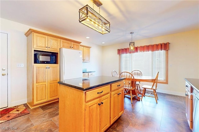 kitchen with baseboards, freestanding refrigerator, hanging light fixtures, black microwave, and dark countertops