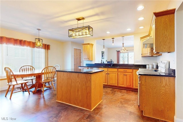 kitchen with dark countertops, pendant lighting, and a kitchen island