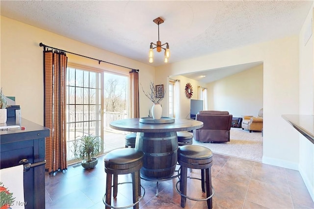 dining space with baseboards and a textured ceiling