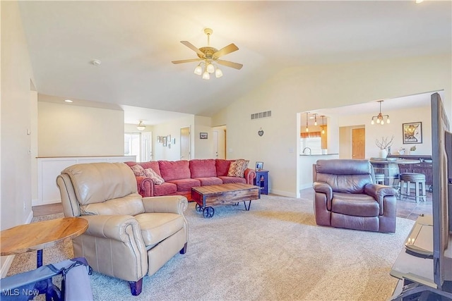 living area with visible vents, ceiling fan with notable chandelier, carpet flooring, baseboards, and vaulted ceiling