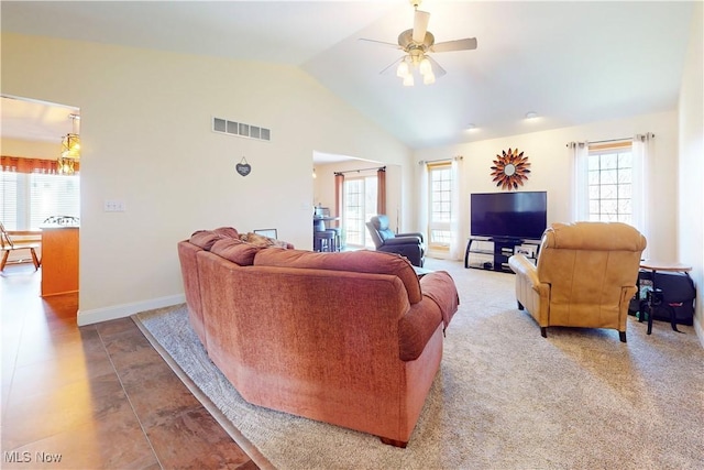 living area featuring vaulted ceiling, a ceiling fan, visible vents, and a wealth of natural light