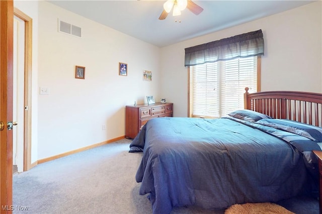 carpeted bedroom featuring baseboards, visible vents, and ceiling fan