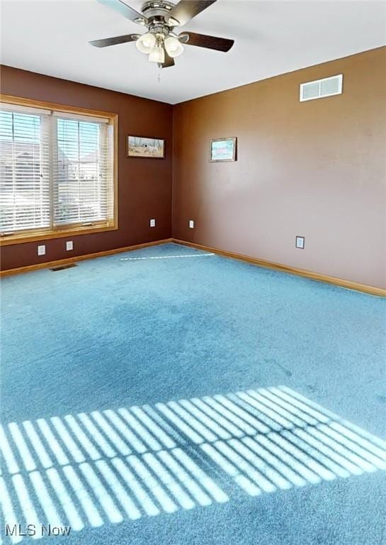 unfurnished room with visible vents, baseboards, carpet, and a ceiling fan