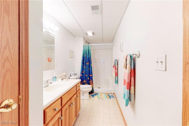 bathroom with visible vents, a drop ceiling, toilet, a stall shower, and vanity