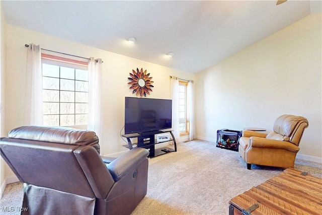 living area featuring a wealth of natural light, baseboards, carpet, and vaulted ceiling