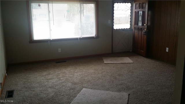 entryway featuring visible vents, baseboards, and carpet