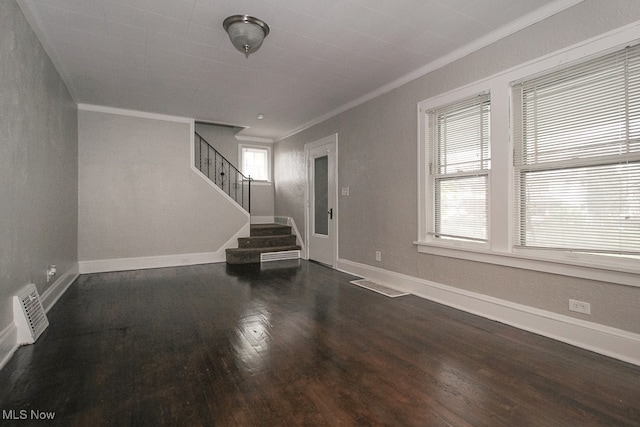 unfurnished living room with stairway, wood finished floors, baseboards, and ornamental molding