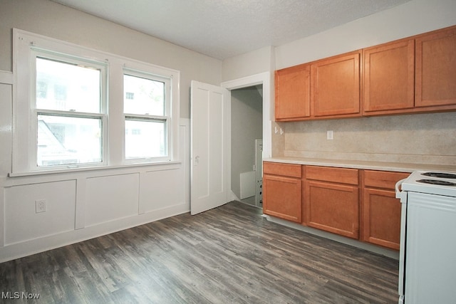 kitchen featuring dark wood-style floors, white range with electric cooktop, light countertops, a textured ceiling, and brown cabinets