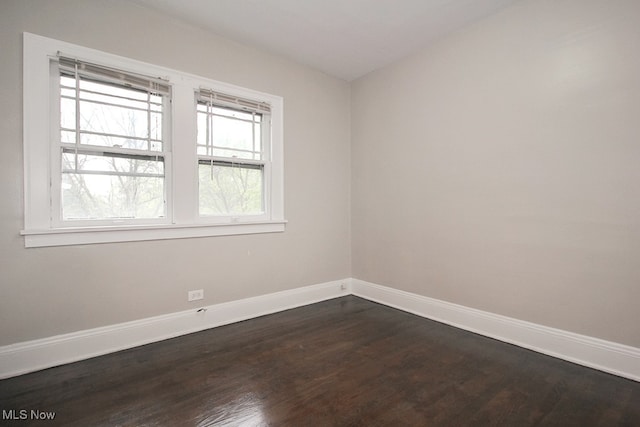unfurnished room with dark wood-style floors and baseboards