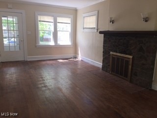 1033 Rushleigh Rd, Cleveland Heights, OH 44121 - unfurnished living room featuring a glass covered fireplace, baseboards, wood finished floors, and crown molding