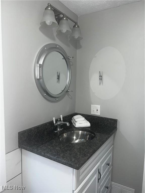 2326 Canfield Rd, Akron, OH 44312 - bathroom with visible vents, a textured ceiling, and vanity