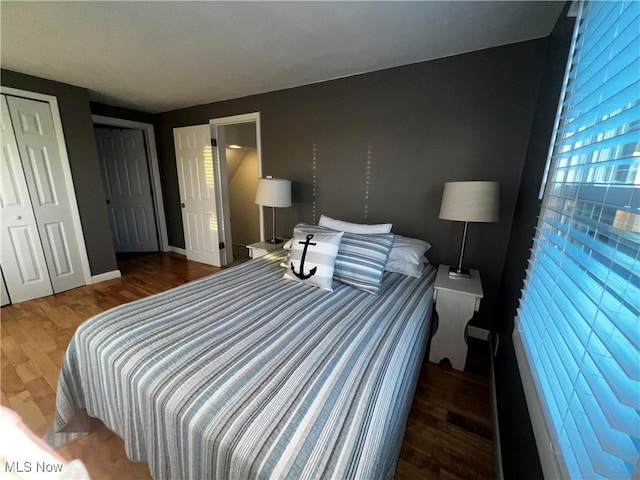 2326 Canfield Rd, Akron, OH 44312 - bedroom featuring wood finished floors, baseboards, and two closets