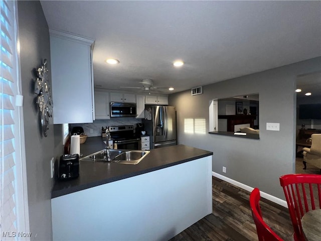 2326 Canfield Rd, Akron, OH 44312 - kitchen featuring a peninsula, dark wood-style flooring, ceiling fan, appliances with stainless steel finishes, and dark countertops