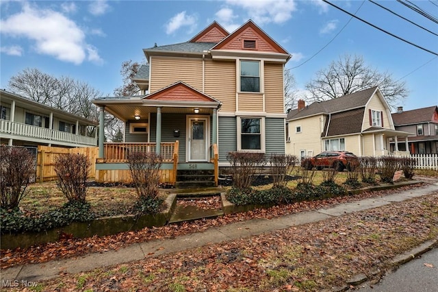 view of front of property with a porch and fence