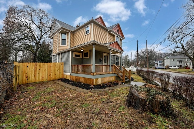 view of front of home featuring a porch and fence