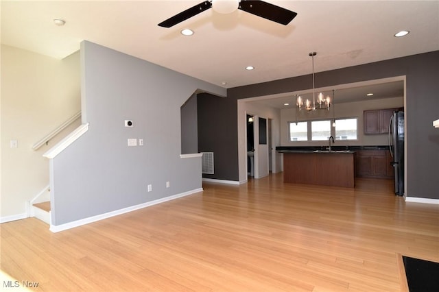 1261 W 74, Cleveland, OH 44102 - unfurnished living room with a sink, a chandelier, light wood-type flooring, a ceiling fan, and baseboards