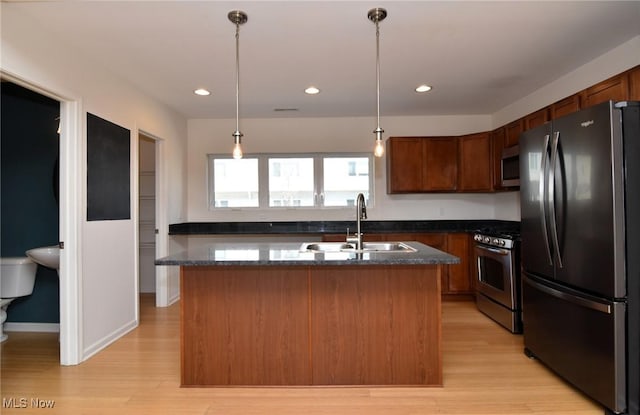 1261 W 74, Cleveland, OH 44102 - kitchen featuring stainless steel appliances, a sink, light wood-style flooring, dark stone counters, and pendant lighting