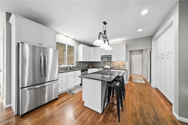 4100 Chagrin River Rd, Moreland Hills, OH 44022 - kitchen with appliances with stainless steel finishes, a sink, a kitchen island, white cabinetry, and decorative backsplash