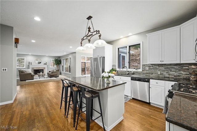 4100 Chagrin River Rd, Moreland Hills, OH 44022 - kitchen with stainless steel appliances, a sink, decorative backsplash, open floor plan, and white cabinets