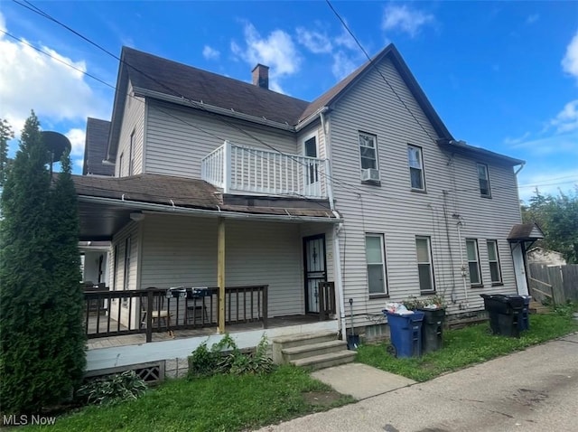 3782 W 38th St, Cleveland, OH 44109 - back of house with a chimney, covered porch, a balcony, and roof with shingles