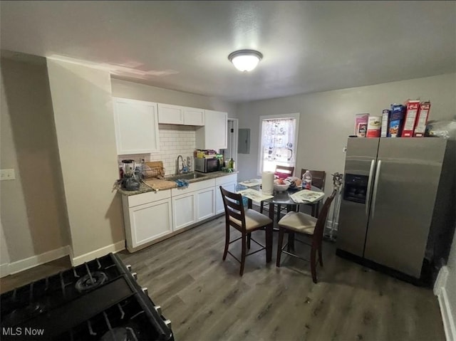 3782 W 38th St, Cleveland, OH 44109 - kitchen featuring stainless steel fridge with ice dispenser, a sink, wood finished floors, and white cabinetry