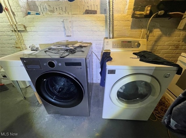 3782 W 38th St, Cleveland, OH 44109 - laundry area with separate washer and dryer and brick wall