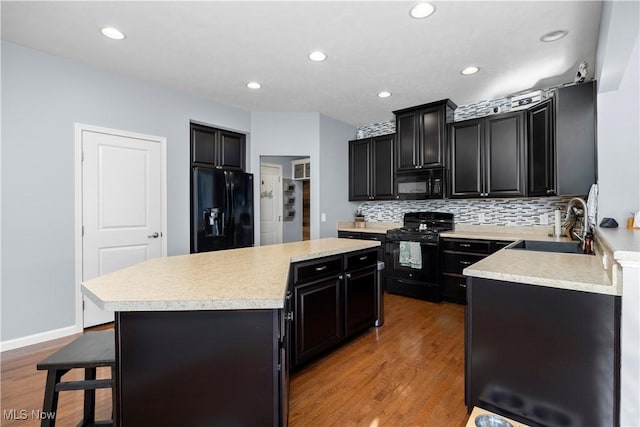 3186 Blackburn Ln, Brunswick, OH 44212 - kitchen featuring black appliances, a sink, dark cabinetry, a center island, and recessed lighting