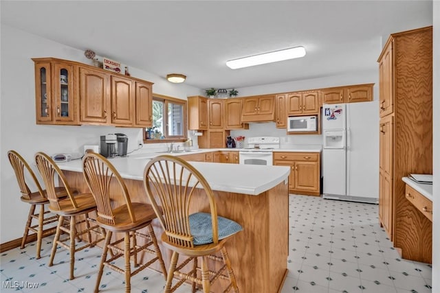 9620 Bimeler St NE, Bolivar, OH 44612 - kitchen featuring white appliances, light floors, a peninsula, glass insert cabinets, and a kitchen bar