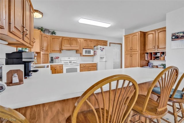 9620 Bimeler St NE, Bolivar, OH 44612 - kitchen with white appliances, a peninsula, a breakfast bar area, and light countertops