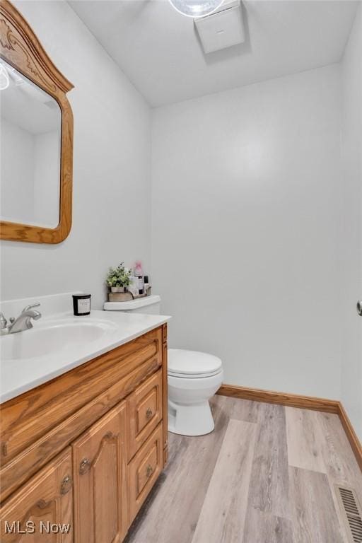 9620 Bimeler St NE, Bolivar, OH 44612 - half bath with visible vents, toilet, wood finished floors, baseboards, and vanity