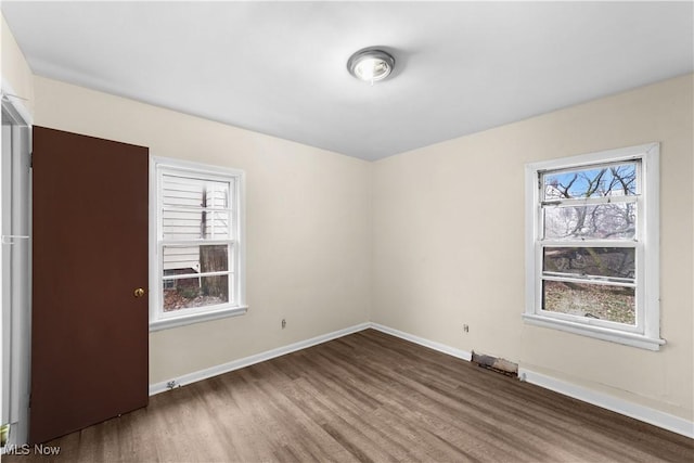 empty room with wood finished floors and baseboards