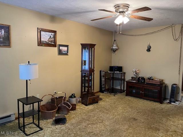 misc room featuring carpet flooring, a ceiling fan, a baseboard heating unit, and a textured ceiling