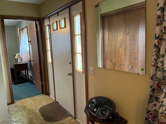doorway to outside with plenty of natural light and carpet flooring