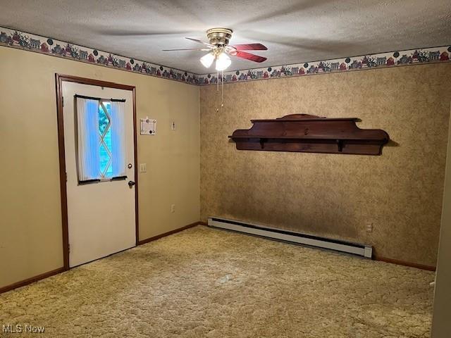 carpeted spare room featuring a baseboard radiator, ceiling fan, baseboards, and a textured ceiling