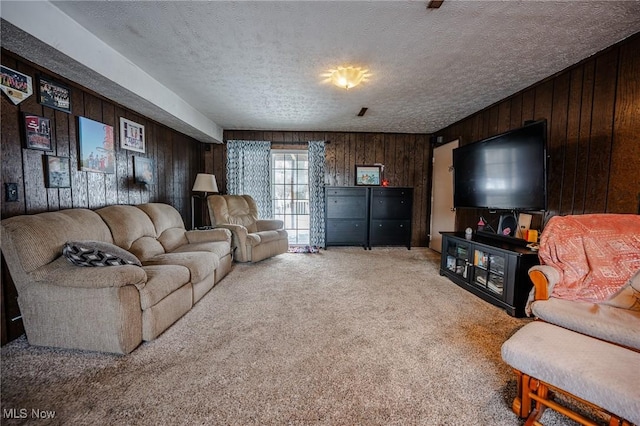 carpeted living area featuring wooden walls and a textured ceiling