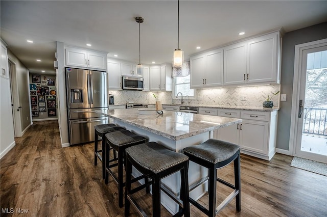 kitchen with dark wood-type flooring, white cabinetry, and appliances with stainless steel finishes
