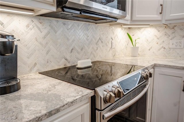kitchen with white cabinets, decorative backsplash, light stone counters, and stainless steel appliances