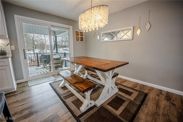 dining area with wood finished floors, an inviting chandelier, and baseboards