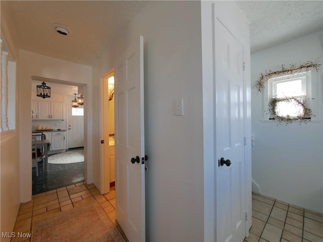 2616 Eldersville Rd, Follansbee, WV 26037 - corridor with an inviting chandelier, light tile patterned flooring, and a textured ceiling