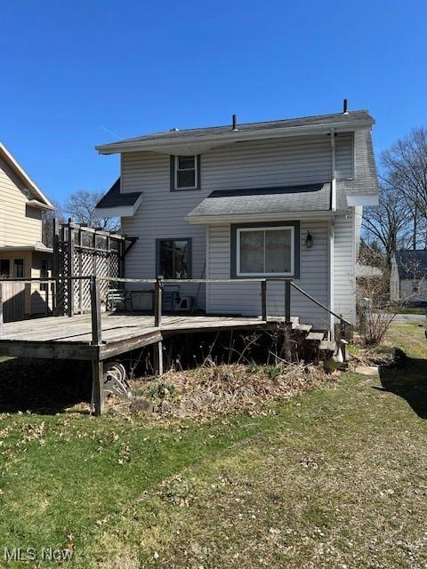 back of house with a wooden deck and a yard