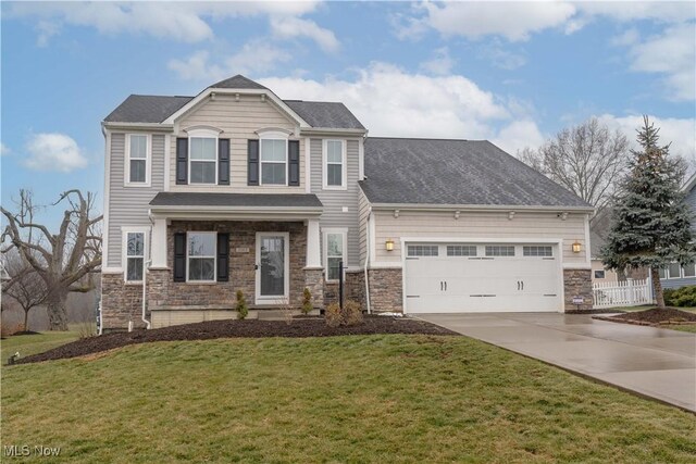 view of front of home featuring stone siding, driveway, an attached garage, and a front yard