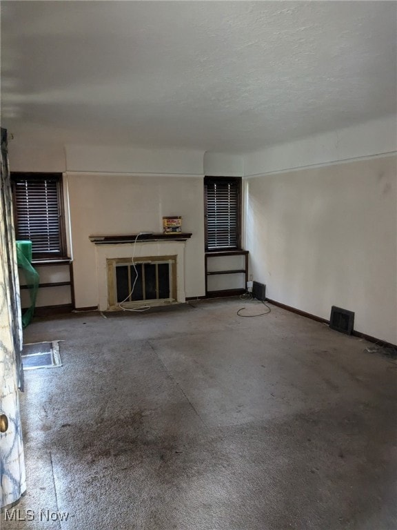 3643 Lindholm Rd, Shaker Heights, OH 44120 - unfurnished living room with baseboards, a textured ceiling, and a high end fireplace
