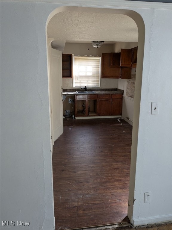 3643 Lindholm Rd, Shaker Heights, OH 44120 - kitchen with a sink, arched walkways, dark wood-style flooring, and a textured ceiling